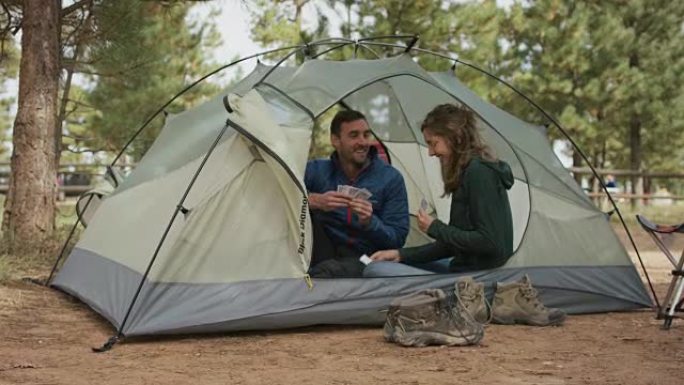 夫妇在帐篷里打牌热恋情侣山林中休闲娱乐周