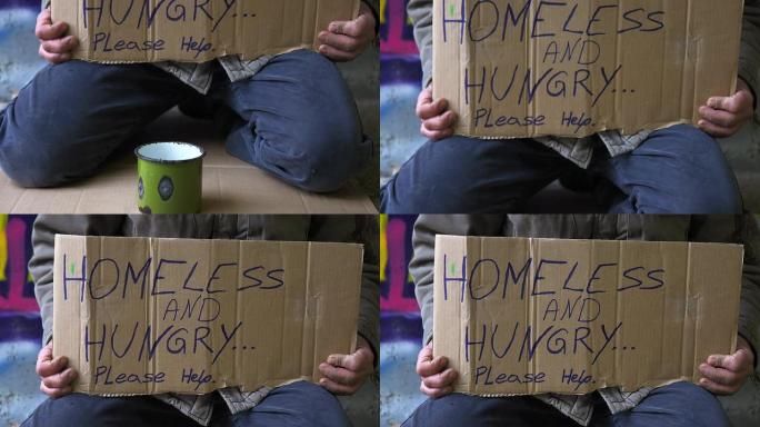 高清: 无家可归的人跪着纸板标志