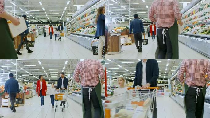 在超市: 幸福的三口之家牵着手走过商店的新鲜农产品区。父亲推着购物车，母女牵着手，玩得开心。