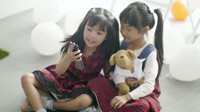 两姐妹使用电话小女孩玩手机