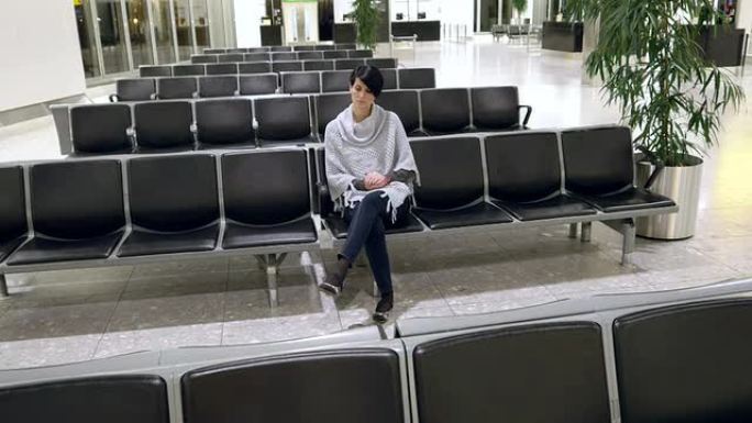 绝望的女人坐在机场的候机室里