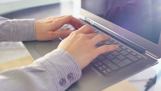 年轻的商务女性使用笔记本电脑打字