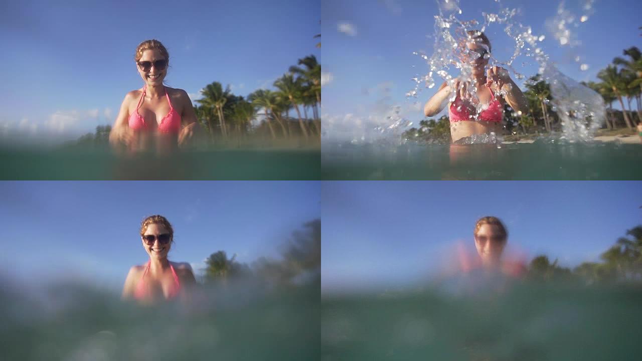 女人在海里享受并溅入相机