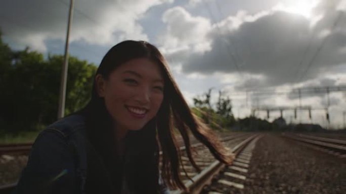 亚洲女人在铁路卡车上微笑着晒太阳。
