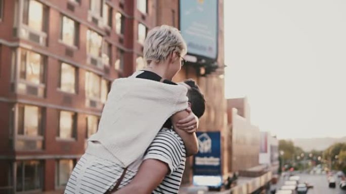 慢动作快乐的年轻人遇见他的女朋友，抱着她，在令人惊叹的纽约日落大桥上旋转