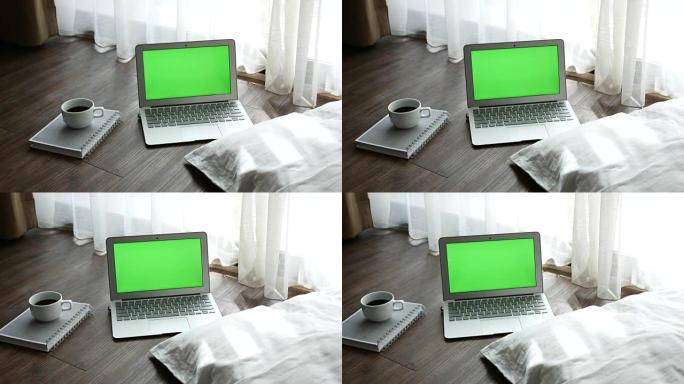 绿屏笔记本电脑在木地板上显示一本书和一杯咖啡，多莉射击
