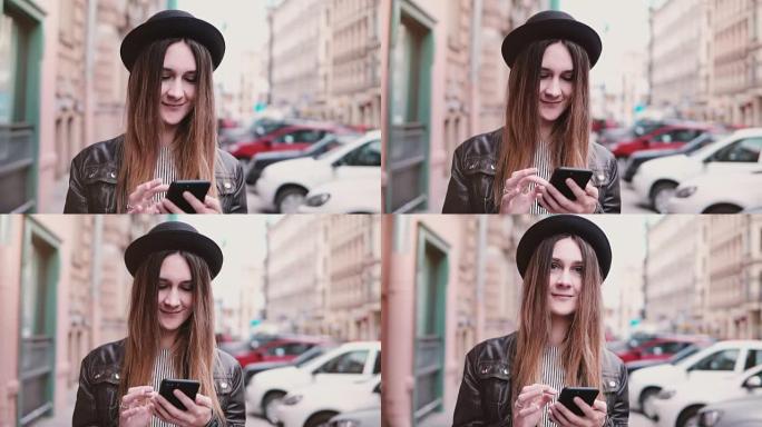 戴着时尚帽子微笑的年轻欧洲女性带着智能手机走在城市街道上，向前看慢动作