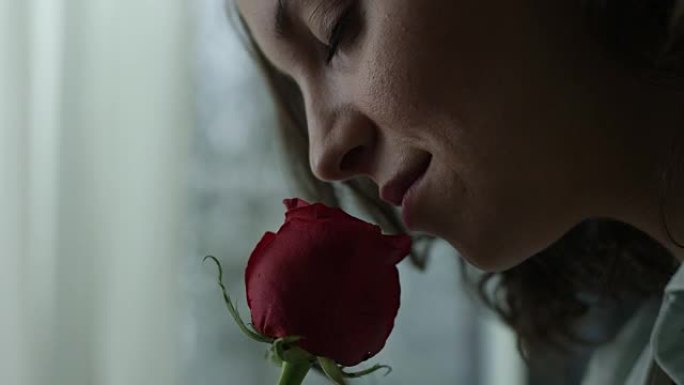 闻红玫瑰的年轻女子