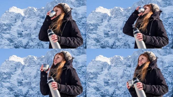 女人在雪山的热水瓶里喝酒