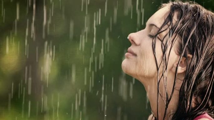 女人在夏雨中享受并握住她的手