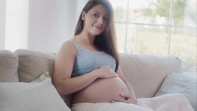 孕妇抚摸她的肚子孕妈妈抚摸自己的孕肚