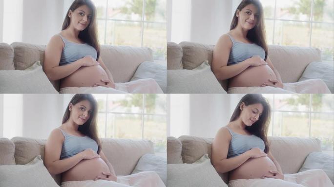 孕妇抚摸她的肚子孕妈妈抚摸自己的孕肚