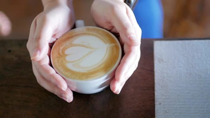 女人的手在咖啡馆里拿着一杯咖啡
