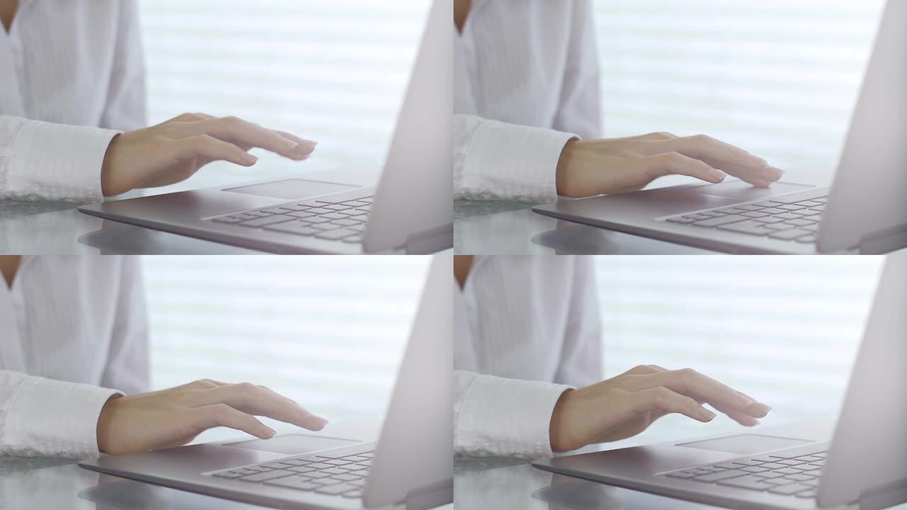 年轻的商务女性使用笔记本电脑触摸板