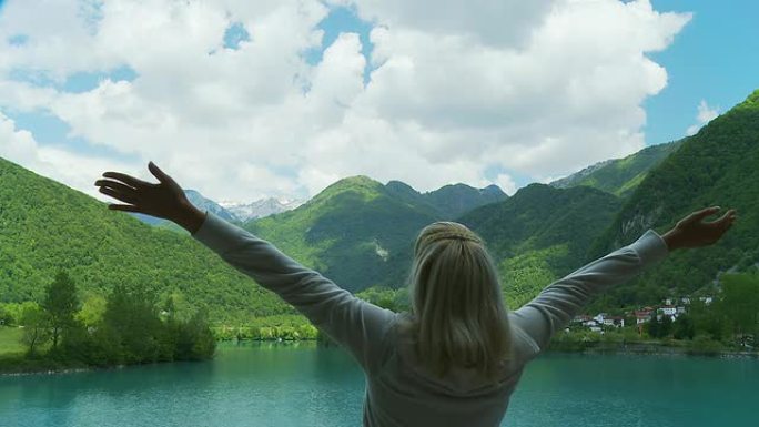 高清：快乐女人在湖边伸展手臂