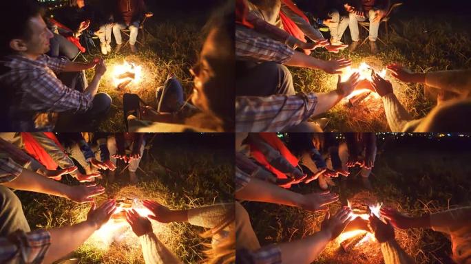 快乐的人们在篝火旁休息。晚上时间