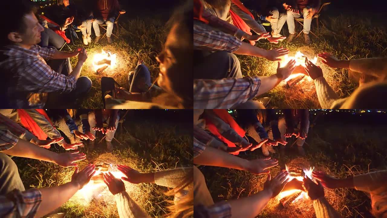 快乐的人们在篝火旁休息。晚上时间