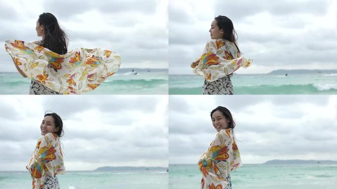 沙滩上围巾的年轻幸福女人，慢动作