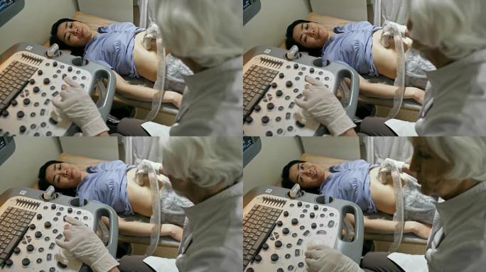 亚洲女性接受超声波检查并与高级医生交谈