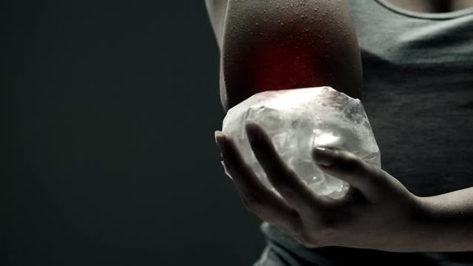 一名女子将冰块放在疼痛的肘部