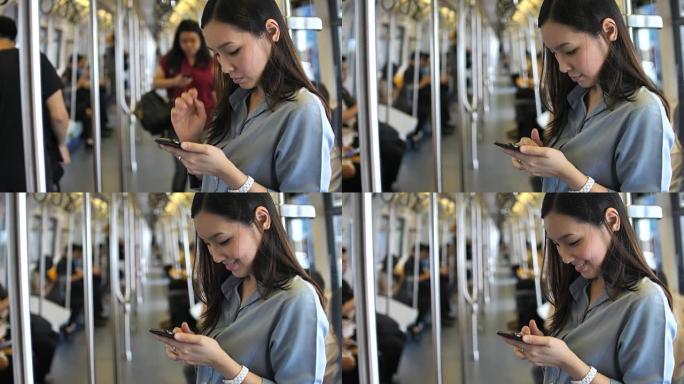 年轻女子在火车上使用智能手机