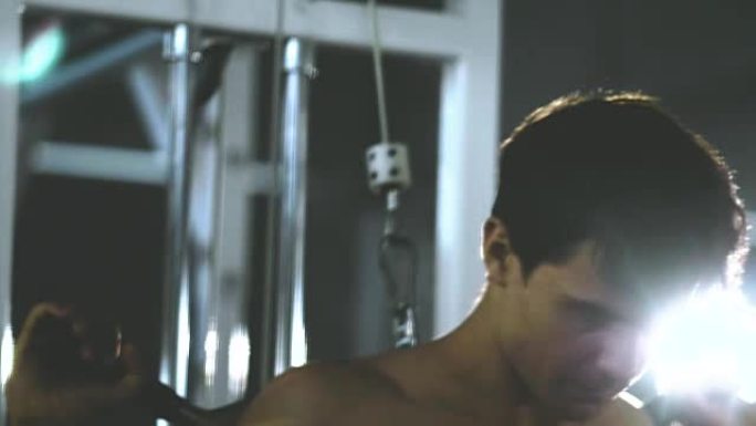 镜头耀斑: 男子在健身房锻炼，视频慢动作