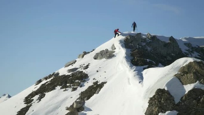 爬上白雪覆盖的山顶的登山者