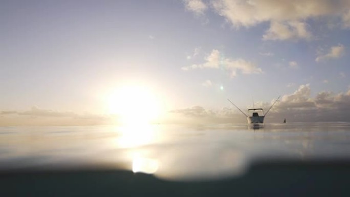 日落时在海上缓慢摇摆的船的景色