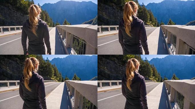 年轻女子在山腰的混凝土桥上行走