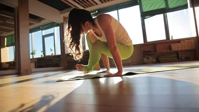 一位30多岁的私人教练在瑜伽工作室的垫子上做体式