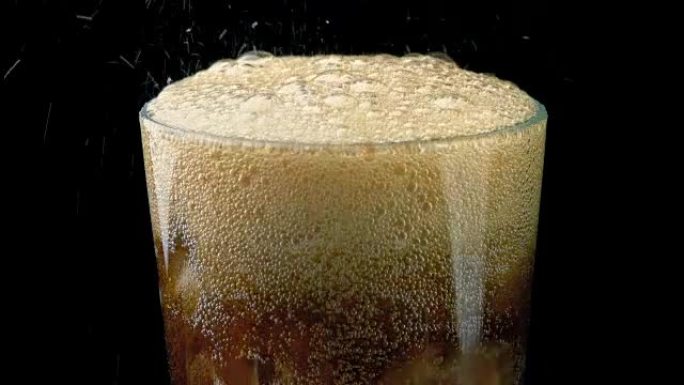 可乐倒入冰块的玻璃杯中