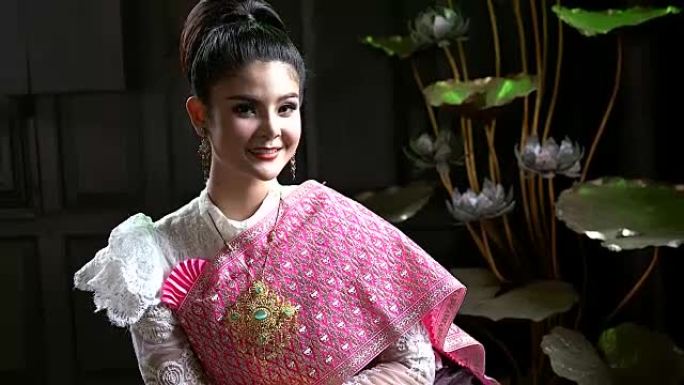 穿着泰国传统服装的亚洲妇女的肖像对着镜头微笑。