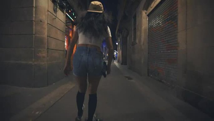 女人晚上在街上滑板