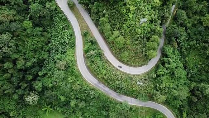 森林中蜿蜒道路的鸟瞰图和汽车驾驶，安全驾驶理念