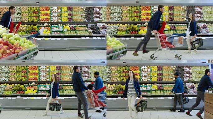 在超市: 男人推着购物车，女人坐在购物车里，幸福的夫妇在手推车里穿过商店的新鲜农产品区玩得很开心。侧