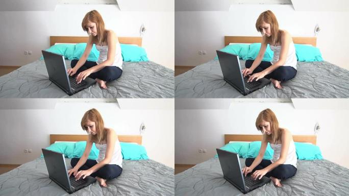 年轻女子坐在床上，用笔记本电脑聊天