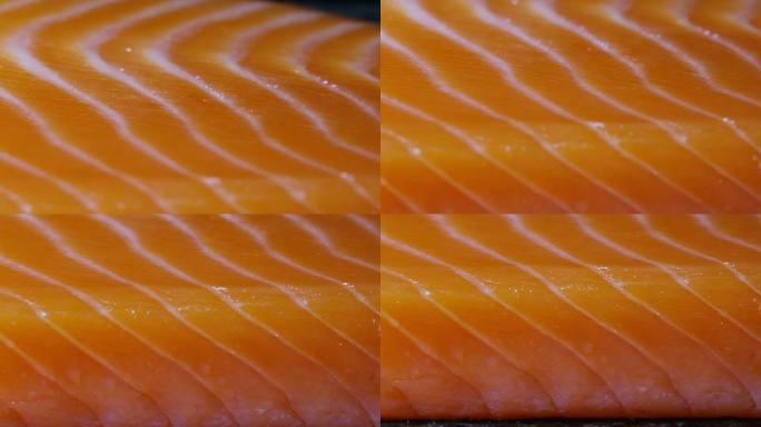 一片新鲜三文鱼在极端宏观特写。从鱼中摄取的欧米茄3和维生素。生物野生鲑鱼，鲑鱼鳟鱼。