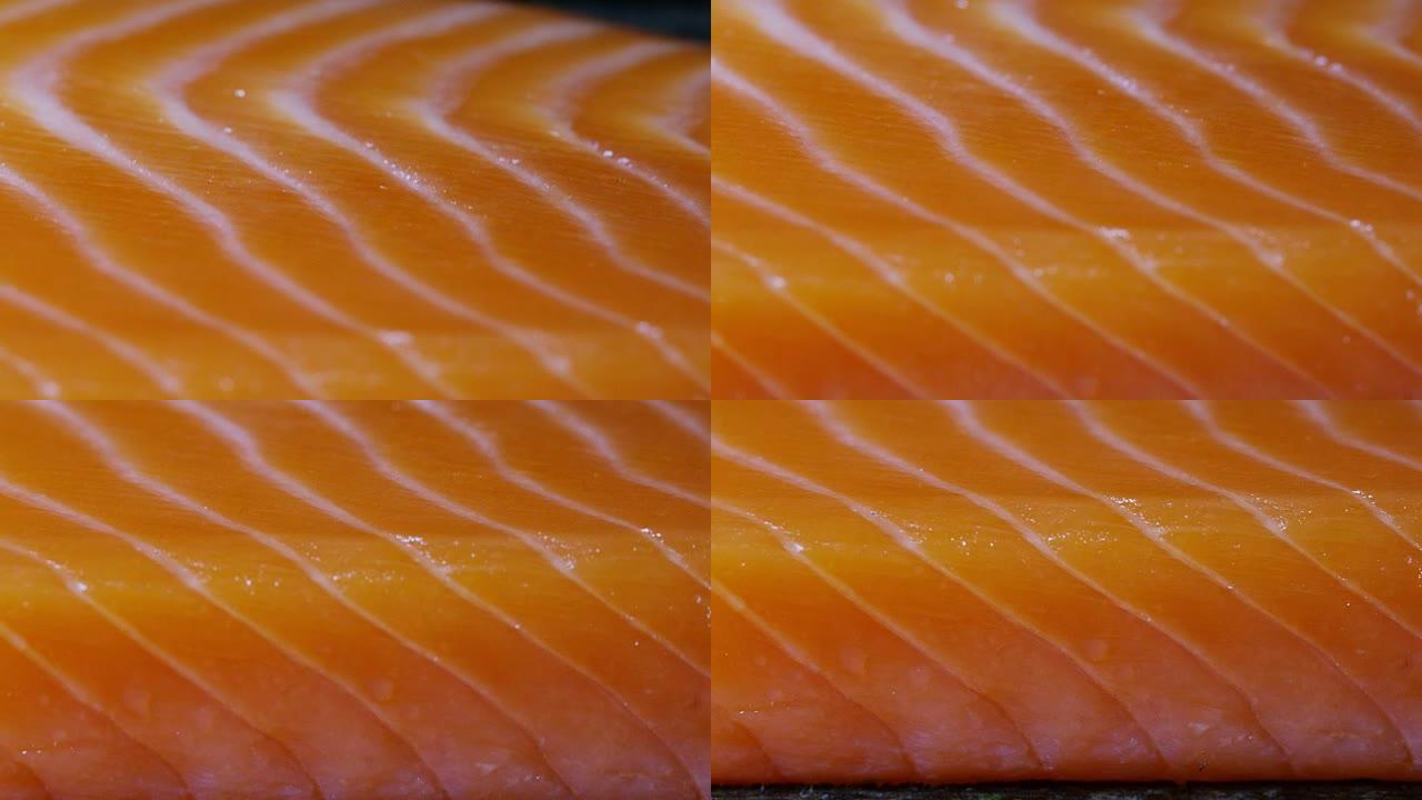 一片新鲜三文鱼在极端宏观特写。从鱼中摄取的欧米茄3和维生素。生物野生鲑鱼，鲑鱼鳟鱼。