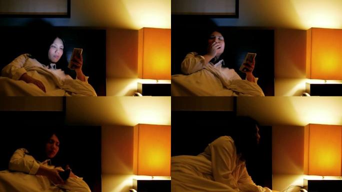 女人在睡觉前关掉灯前使用智能手机和困倦