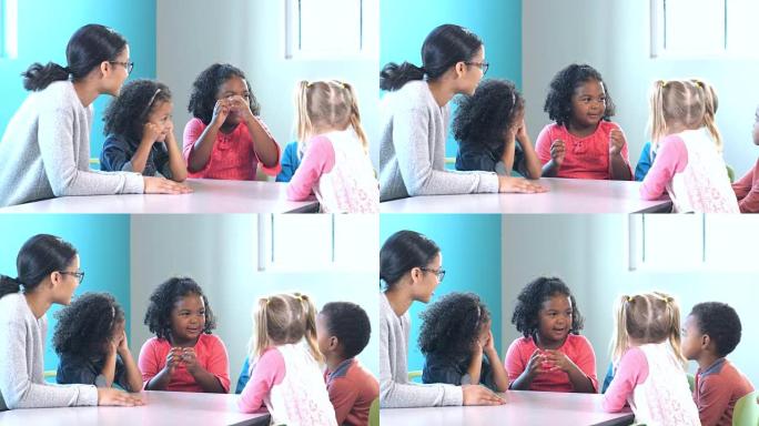 一群学龄前儿童与老师，女孩在说话