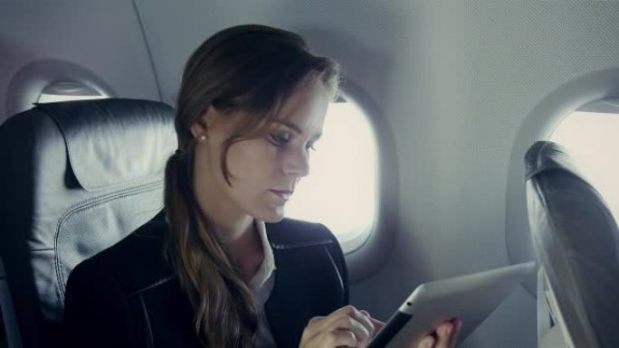 飞机上的女商人商务精英平板电脑讨论外国人