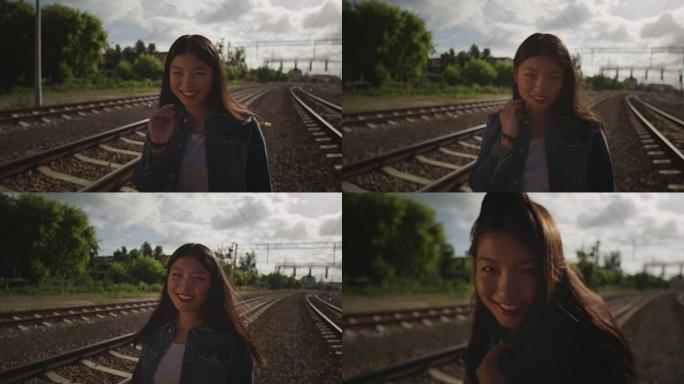 害羞的亚洲年轻女子独自在铁路上。