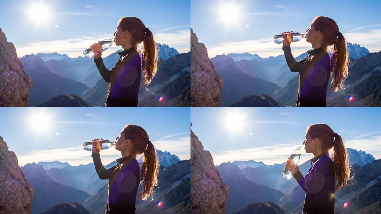年轻女子在山顶喝水