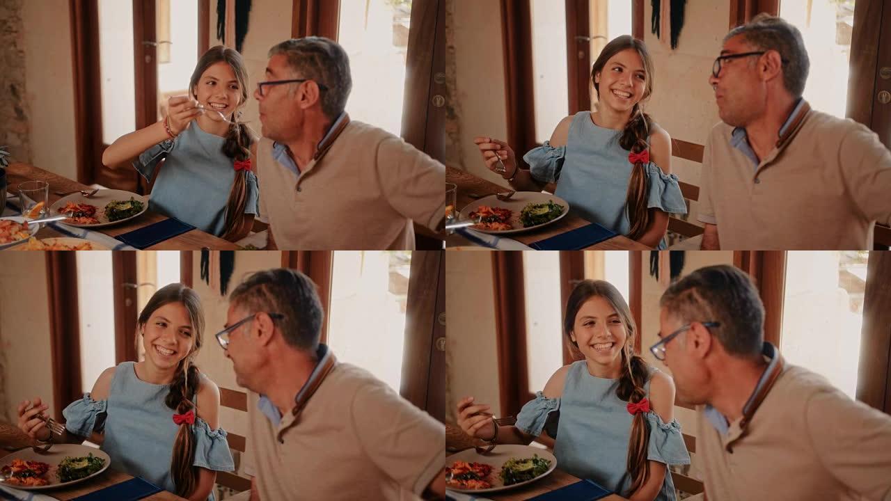 祖父和孙女在家吃午饭时玩得开心