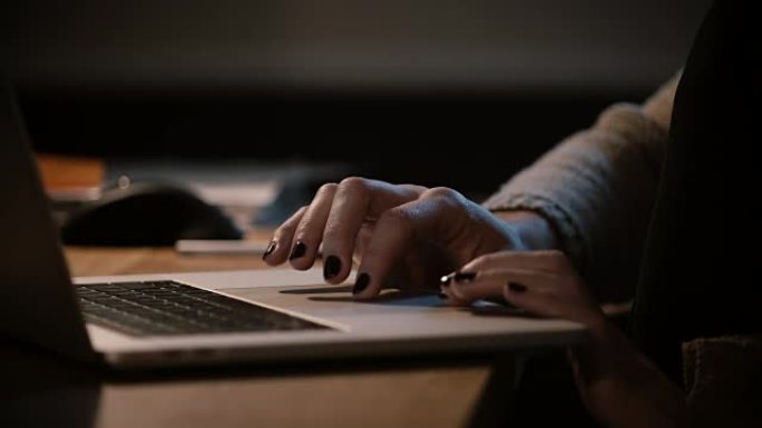 使用笔记本电脑触控板的特写女性手指。女人上网，深夜手放在笔记本触摸板上。4K