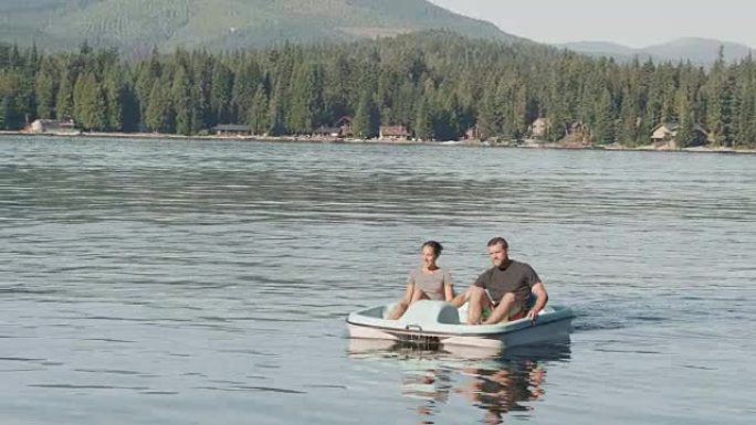 夫妇在平静的湖上使用划桨船