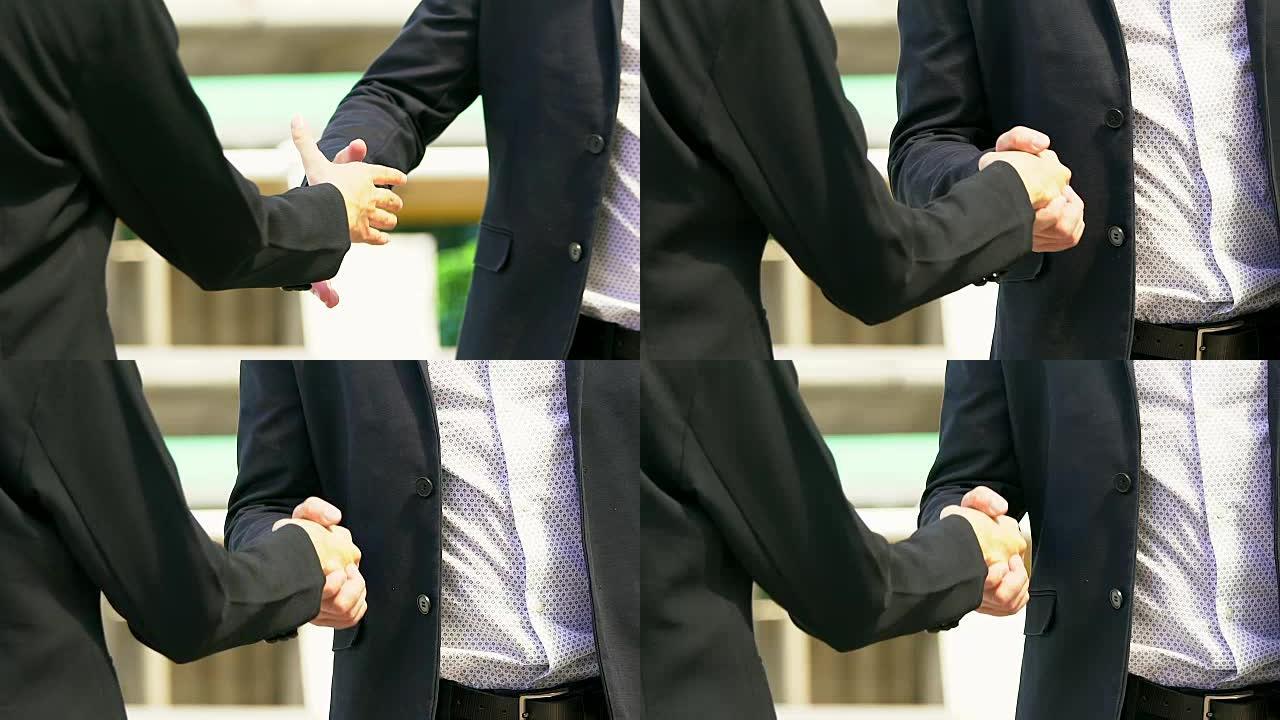 两名男子的商业握手，表明他们同意在他们的公司/企业之间签署协议或合同。