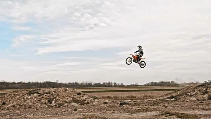 SLO MO越野摩托车手跳过泥土坡道