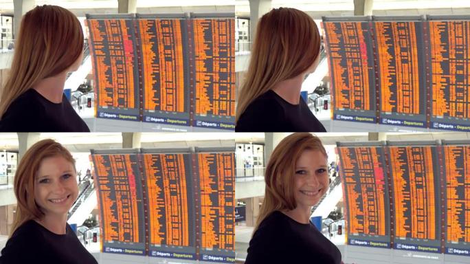 女人在机场看着飞机飞行信息板