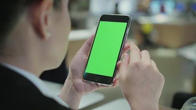 在咖啡店使用智能手机的肩膀拍摄，绿屏
